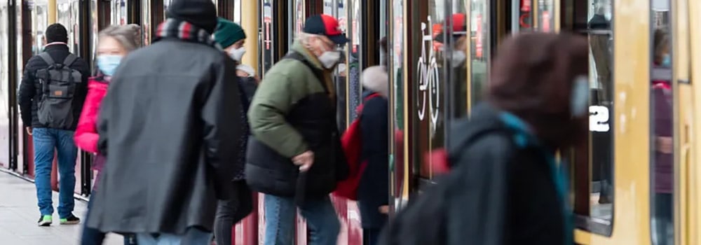 Menschen mit FFP2-Masken steigen in S-Bahn ein und aus